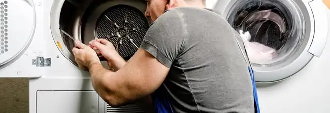 Dryer repair technician fixing a clothes dryer drum in Fort Wayne, IN