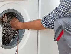 Dryer repair technician diagnosing and servicing a clothes dryer in Fort Wayne, IN