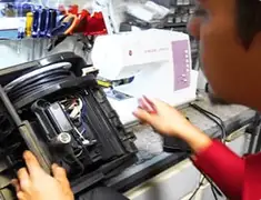 Vacuum repair technician servicing internal components on a workbench in Fort Wayne, IN