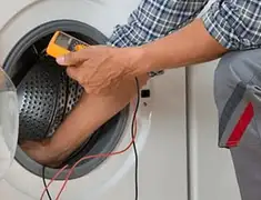 Washing machine repair technician testing a front-load washer with diagnostic tools in Fort Wayne, IN