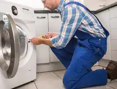 Washing machine repair technician servicing a front-load washer in Fort Wayne, IN